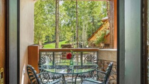 A balcony with a glass table and chairs, a red rose, and a view of a forested area. - DON'T MISS THIS TRUE SKI IN/SKI OUT VILLAGE GEM, PRIME LOCATION, SLEEPS 5 (Beaver Creek)