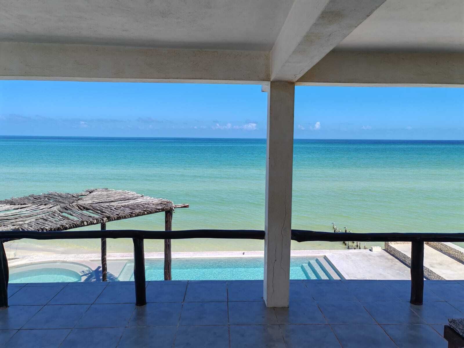 A balcony with a view of the ocean and a pool.