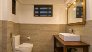 A bathroom with a toilet, sink, and shower. - Bentota Luxe Ayurveda (Bentota)