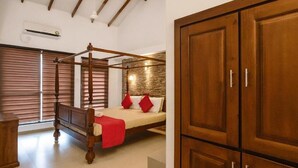 A bedroom with a four-poster bed, wooden wardrobe, and a window with blinds. - Bentota Luxe Ayurveda (Bentota)