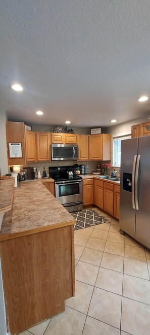 A kitchen with wooden cabinets, stainless steel appliances, and a granite countertop.