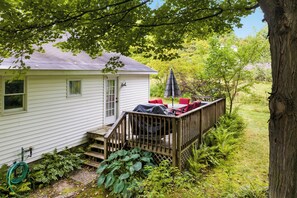 A house with a covered deck, a small porch, and a garden area with various plants. - Ideal Suttons Bay Retreat at Broadway Base Camp (Suttons Bay)
