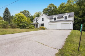 A two-story house with a driveway leading to a garage. - Ideal Suttons Bay Retreat at Broadway Base Camp (Suttons Bay)