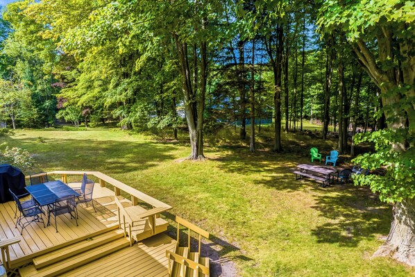 A deck with outdoor furniture, a grassy area, and trees. - 4BR 2BA Home Perfect for a Family in Frankfort (Frankfort)