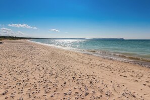 A wide sandy beach with gentle waves and a clear blue sky. - Good Harbour Prelude - Lake Michigan's Best Beach! (Lake Leelanau)