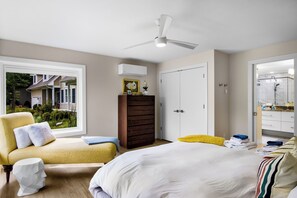 A bedroom with a bed, a chair, a wardrobe, and a ceiling fan. - Stargazer – Modern Luxury Meets Up North Charm (Northport)