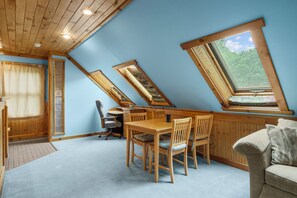 Une pièce avec un plafond en pente, des meubles en bois et des fenêtres de toit.