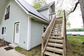 A two-story house with a wooden staircase leading to a balcony.