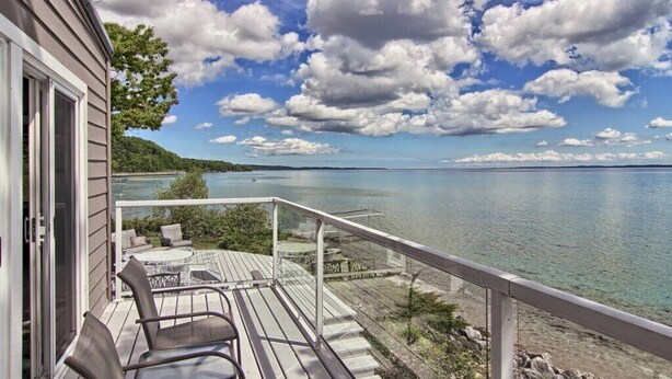 A wooden deck with outdoor furniture overlooking a lake. - Panoramic Point - dazzling views and private beach (Traverse City)