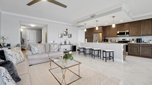 A modern kitchen with dark wooden cabinets, stainless steel appliances, and a central island with bar stools.