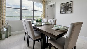 A dining area with a view of the outdoors, featuring a table set with plates, candles, and a decorative centerpiece.