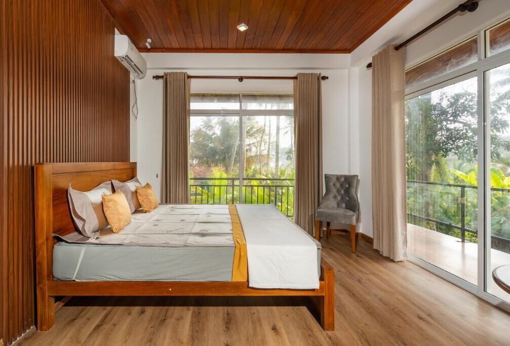 Une chambre avec un lit en bois, une chaise et un balcon offrant une vue.