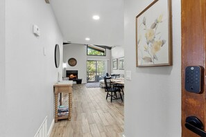 Un intérieur moderne agrémenté d’une cheminée, d’un coin repas et d’œuvres d’art aux murs.