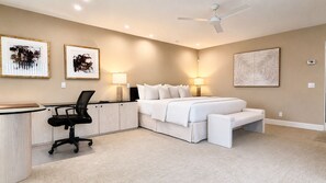 A bedroom with a bed, bedside tables, a desk with a chair, and artwork on the walls. - Grande Vista Villa: 3 bed/3 bath Luxury Living; Stunning Lake & Mountain Views | a Greenday property (Rancho Mirage)