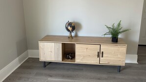 A wooden cabinet with a globe and a potted plant on top. - Cozy 2-bedroom cottage (New Orleans)