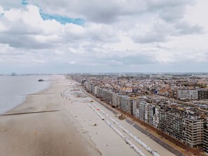 Eine Küstenstadt mit Strand, Wolkenkratzern und blauem Himmel.