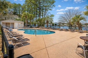 A pool area with lounge chairs, a pool, and surrounding trees. - South Bay East Unit H (Myrtle Beach)