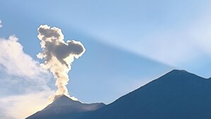 A mountain with a cloud formation and sunlight rays. - Karim Hostal Antigua (Guatemala City)