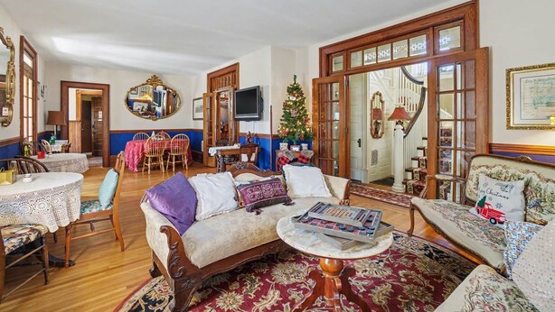 Un salon traditionnel avec une cheminée, des meubles en bois et un sapin de Noël.