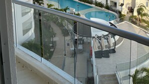 Una vista di un moderno edificio residenziale con piscina, balconi e aree relax all'aperto.