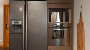 A stainless steel refrigerator with a water dispenser, a microwave, and an oven built into the same unit. - Chalet “Eden” with Balcony and Wi-Fi (Les Belleville)