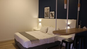 Ein modernes Schlafzimmer mit Bett, Nachttischen und einem Schreibtisch.