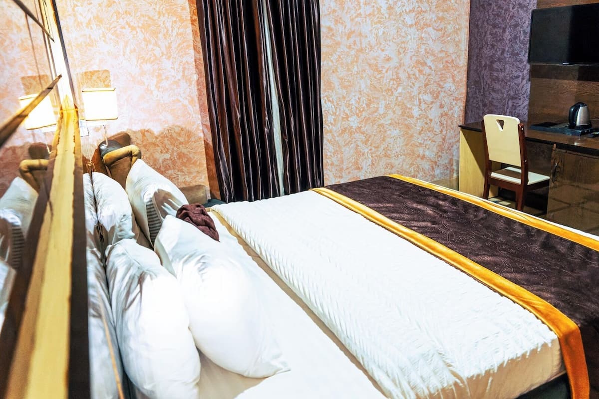 Una habitación de hotel con una cama, un escritorio y una silla.