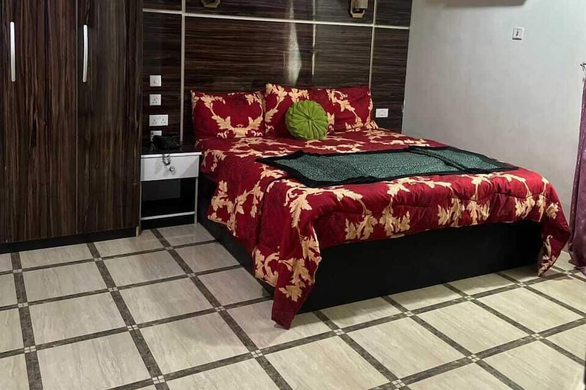 Un dormitorio con cama, armario, mesita de noche y aire acondicionado.