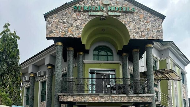 Un hôtel doté d’une façade en pierre, d’une piscine et d’une fresque représentant un paysage.