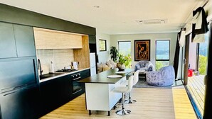 Una cocina moderna con una isla central, armarios oscuros y piso de madera.