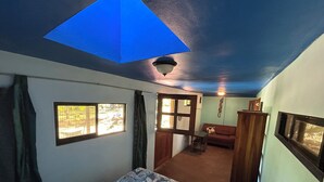 A room with a bed, a sofa, a small table, a window, and a ceiling light. - Montezuma Nicoya Peninsula 3 bedroom house with pool in tropical paradise (Las Delicias, Cobano)