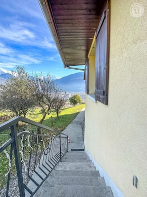 Eine Treppe führt zu einem Balkon mit Blick auf Berge und einen klaren Himmel.