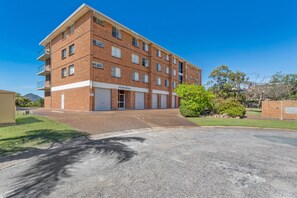 A multi-story brick building with a flat roof, a garage entrance, and a clear sky. - Shoal Bay Sunrise Waterfront Apartment Nelson Bay (Nelson Bay)