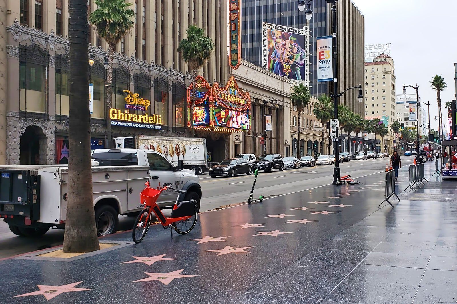 A street with a building featuring a Disney Studio Store and a sign for the Hollywood Walk of Fame.