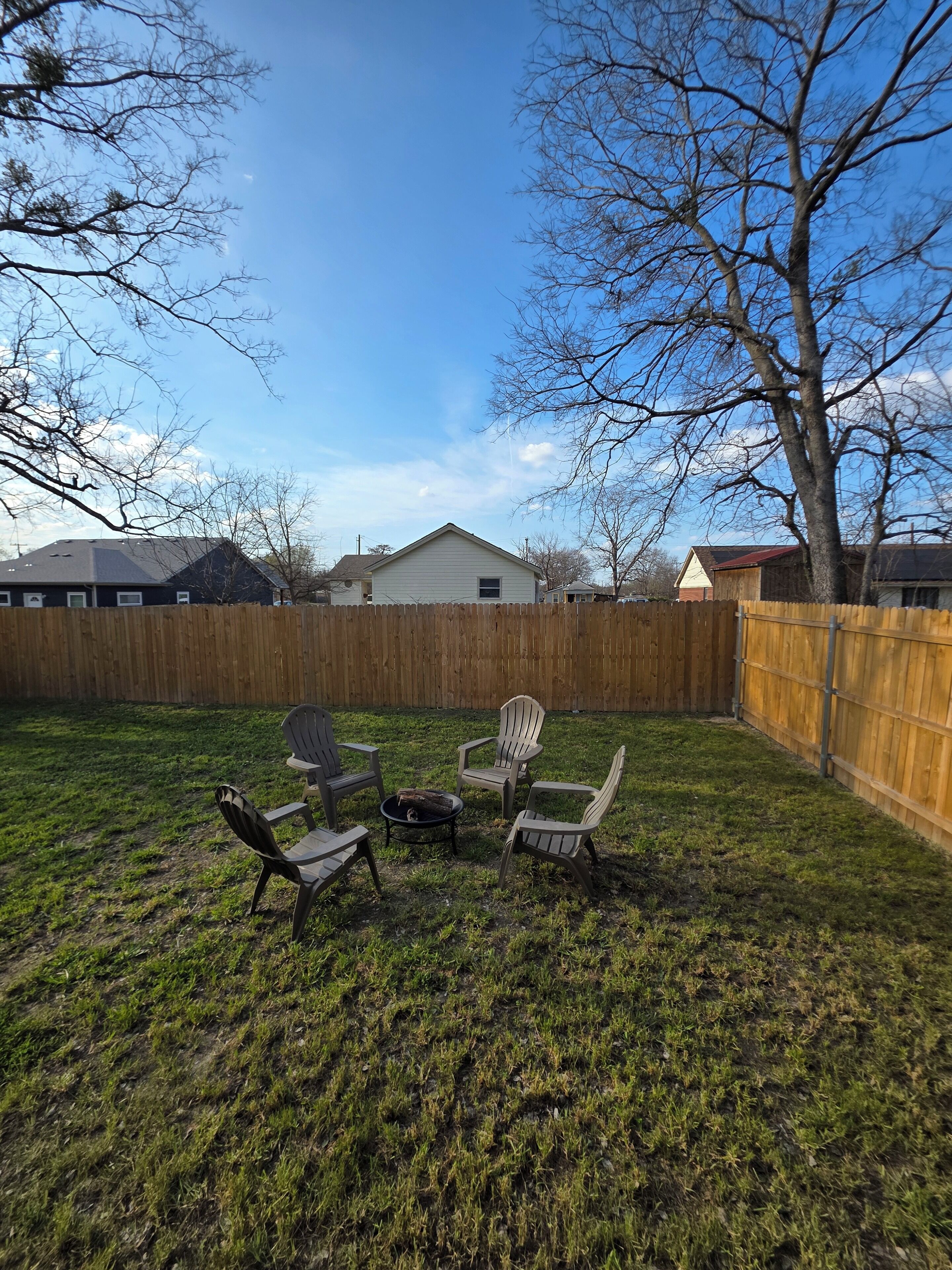 A backyard with a wooden fence, a small shed, and a grassy lawn.
