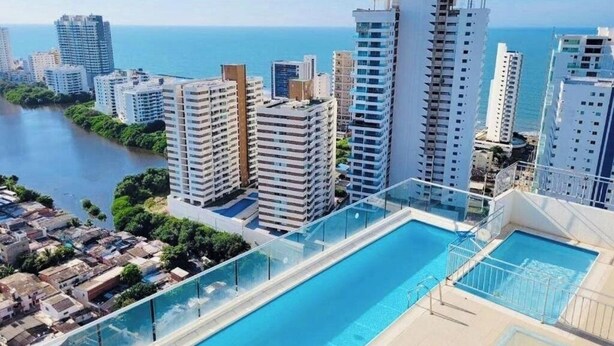 A high-rise building with a rooftop pool overlooking a coastal cityscape. - Ocean view apartment (Cartagena de Indias)