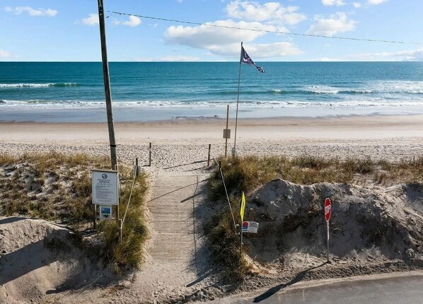 A beach entrance with a stop sign, a flag, and a signboard. - Otter Oasis - Serene 3bd pet-friendly sound views (Surf City)