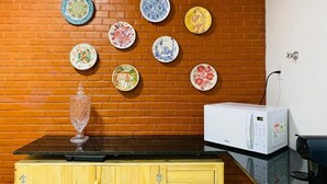 Une cuisine avec un mur en briques, un meuble en bois et un four à micro-ondes.