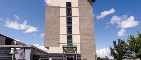 A Premier Inn hotel with a modern design, featuring a large entrance and a clear sky.
