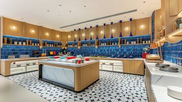 A modern kitchen with a central island, blue tiled backsplash, and wooden cabinetry.