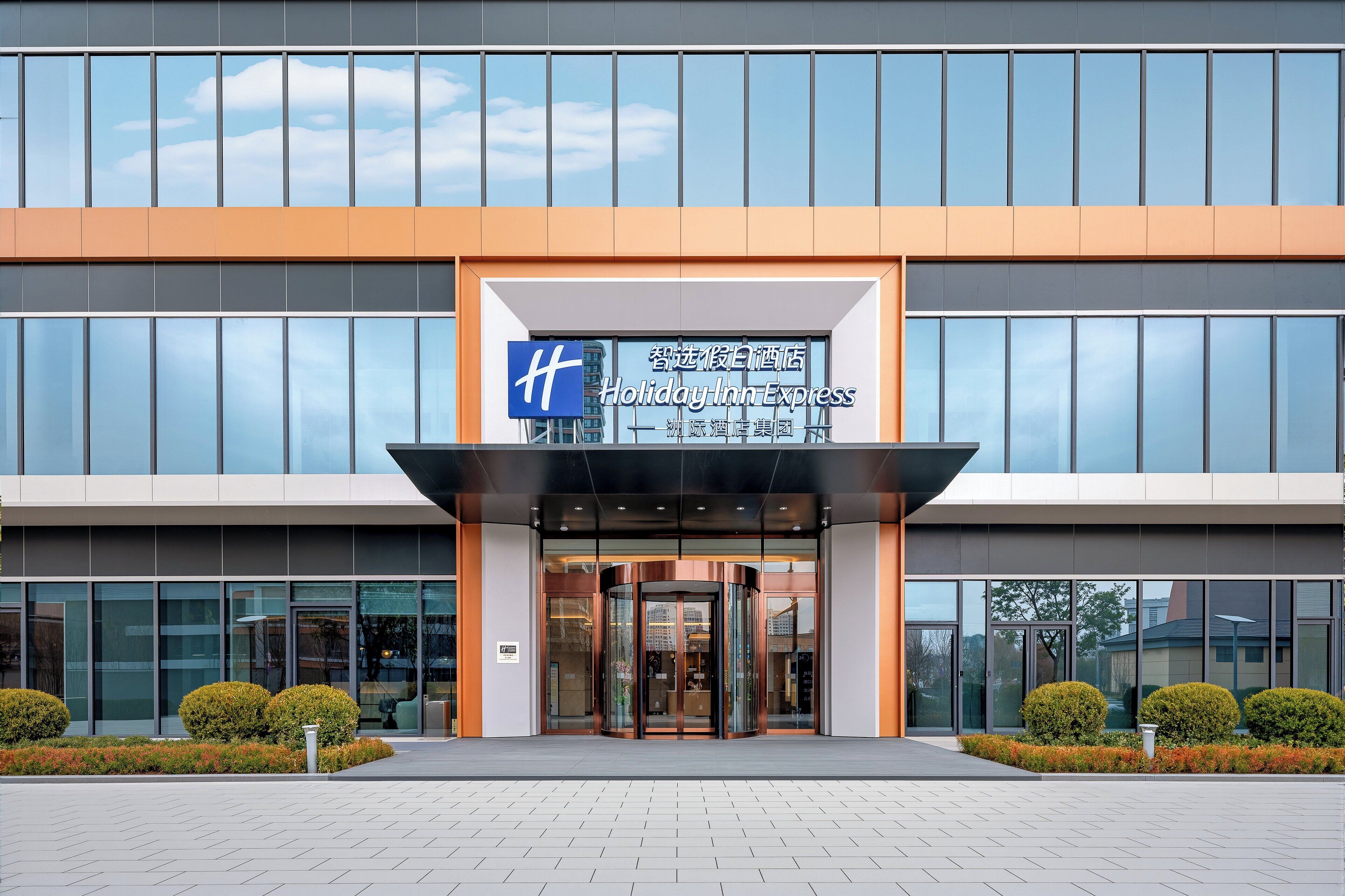 A Holiday Inn Express building with a modern facade, large windows, and a clear entrance.