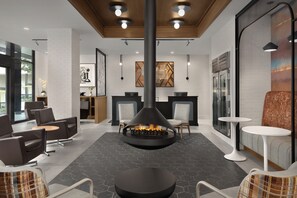 A modern lobby with a central fireplace, seating areas, and a reception desk. - Holiday Inn Express Knoxville Downtown by IHG (Knoxville)