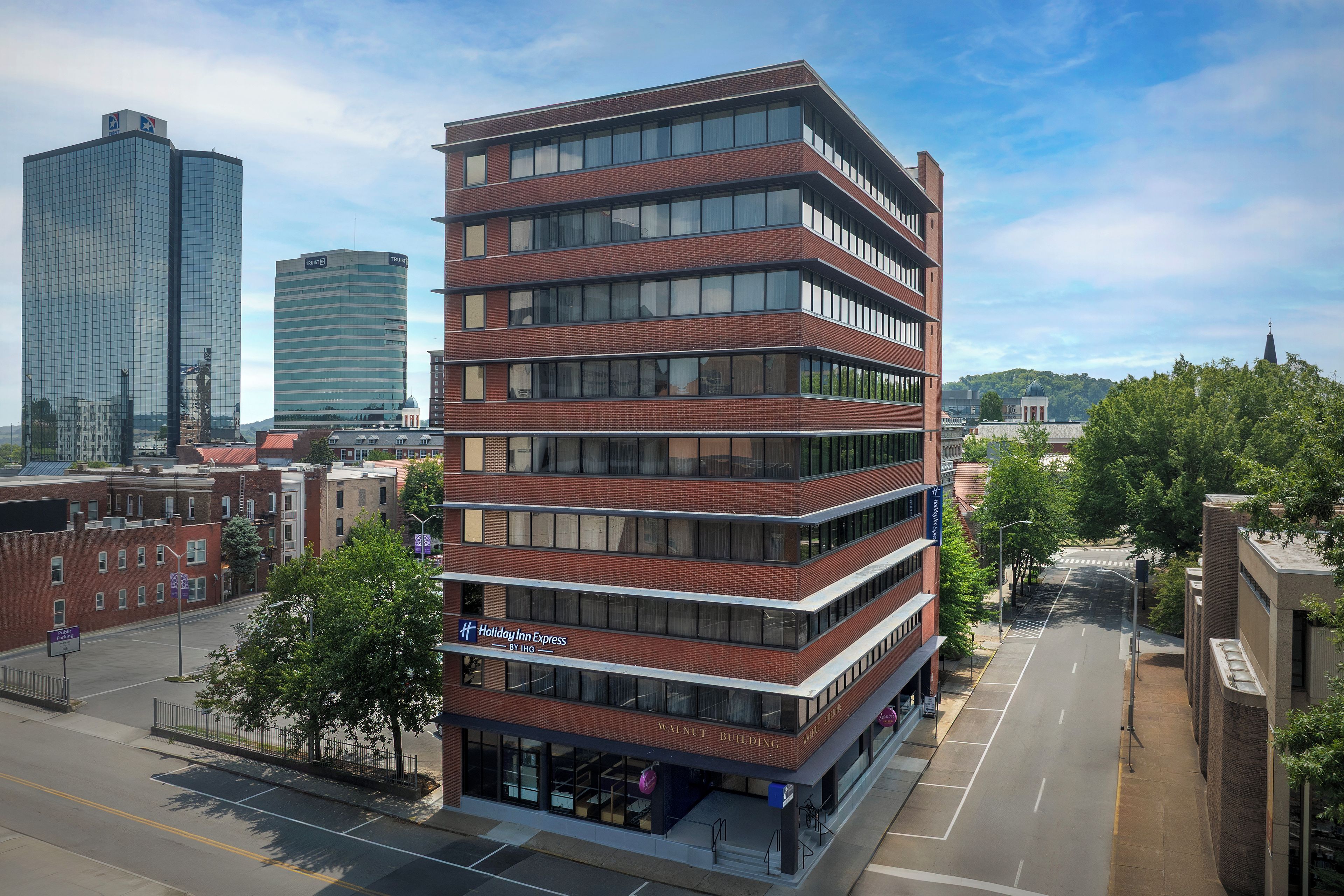 A multi-story hotel with a brick facade, large windows, and a Holiday Inn Express sign.