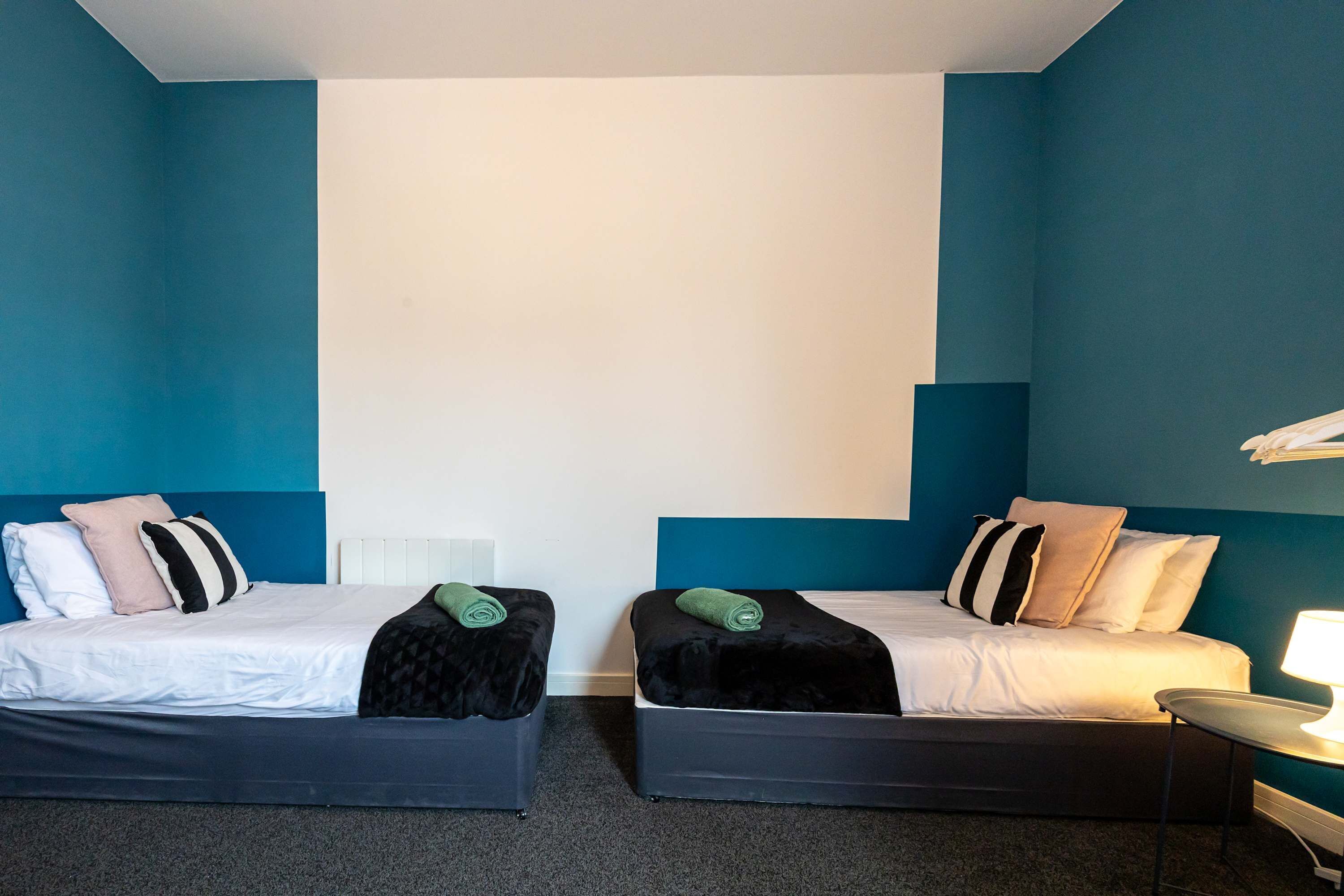 Una habitación de hotel con dos camas, cada una con una almohada y una manta.