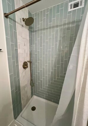 Eine Dusche mit Handbrause und Duschwandhalterung.
