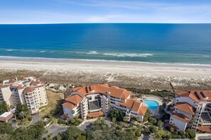 An aerial view of a coastal hotel with multiple buildings, a swimming pool, and a beach in the background. - Sandcastles Suite: Ocean Views Stretching for Miles! (Amelia Island)