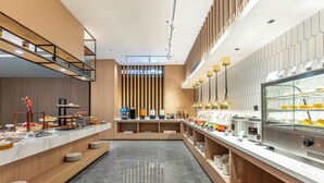 A modern coffee shop with a marble countertop, a coffee machine, and a display case with pastries. - Holiday Inn Express Qinhuangdao Haigang By IHG (Qinhuangdao)