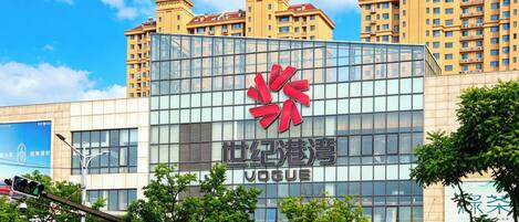Ein modernes Gebäude mit großer Glasfassade, einem markanten roten Logo und der Aufschrift 'Vogue'.