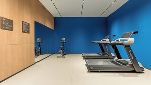 A fitness room with treadmills, a stationary bike, and a wall-mounted exercise bike. - Holiday Inn Express Qinhuangdao Haigang By IHG (Qinhuangdao)
