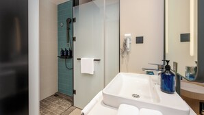 A modern bathroom with a glass shower enclosure, a white sink, and a large mirror. - Holiday Inn Express Qinhuangdao Haigang By IHG (Qinhuangdao)